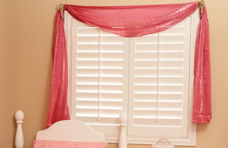 Girl's bedroom with white shutters.